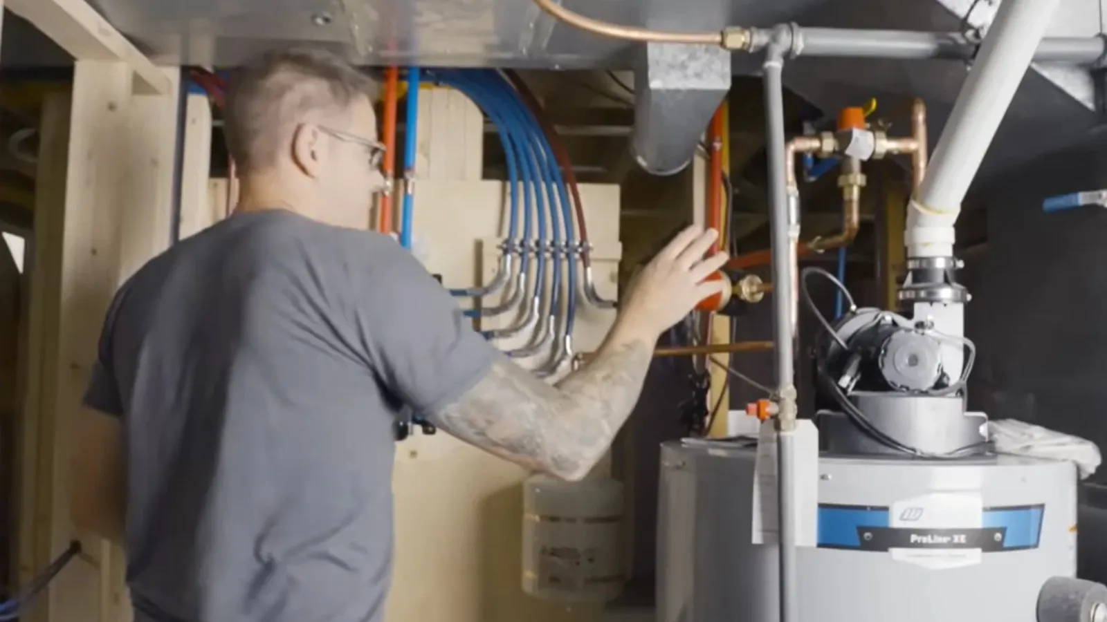 Plumber working on a water heater in a basement during a replacement